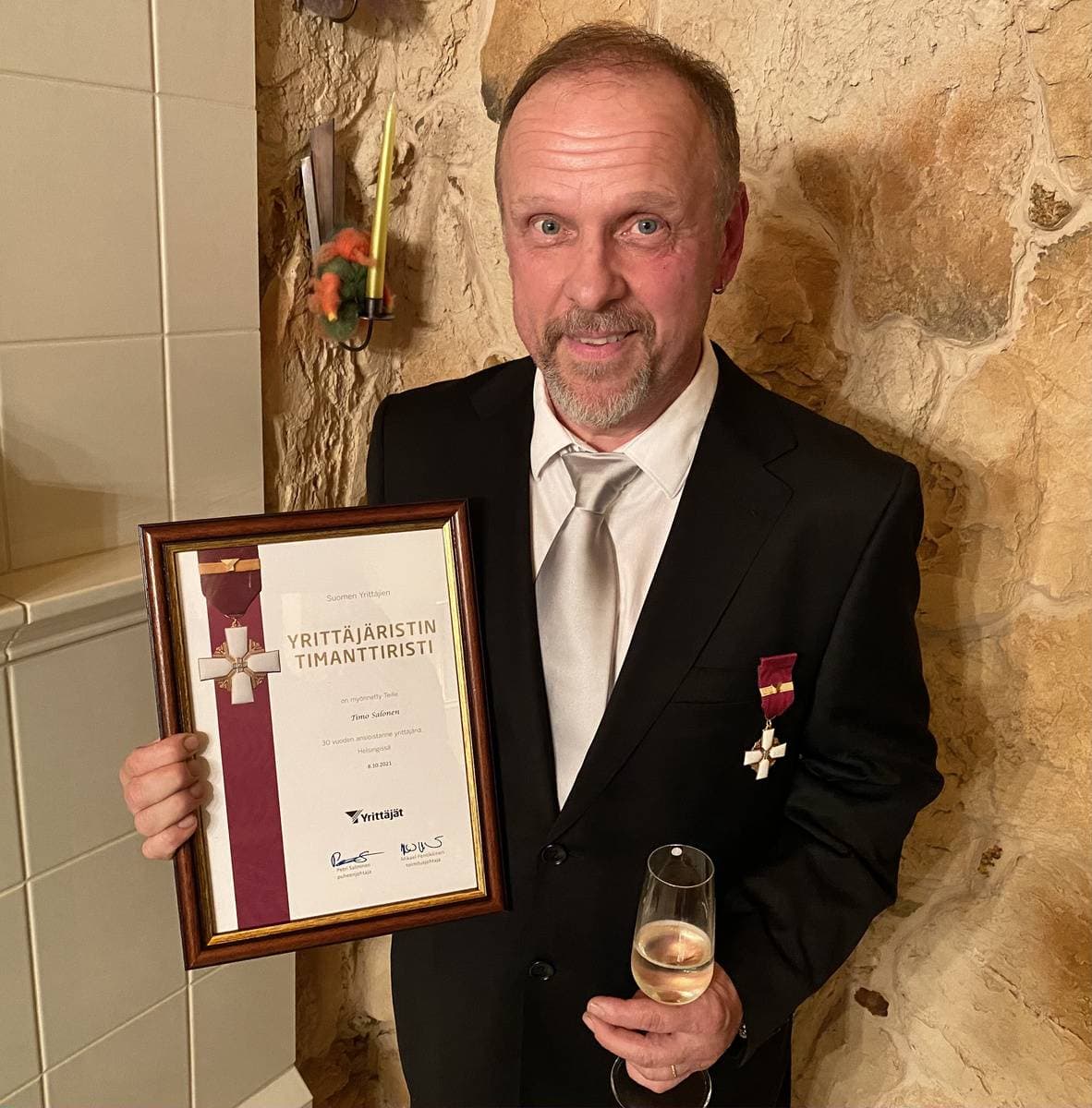 Timo Salonen pitää kädessään Suomen Yrittäjien Timanttiristi-diplomia.